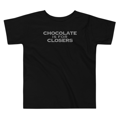 "Chocolate Is For Closers" printed on a black toddler short sleeve tee laying on a flat surface