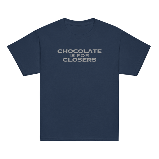 "Chocolate Is For Closers" printed on a navy youth classic tee laying on a flat surface