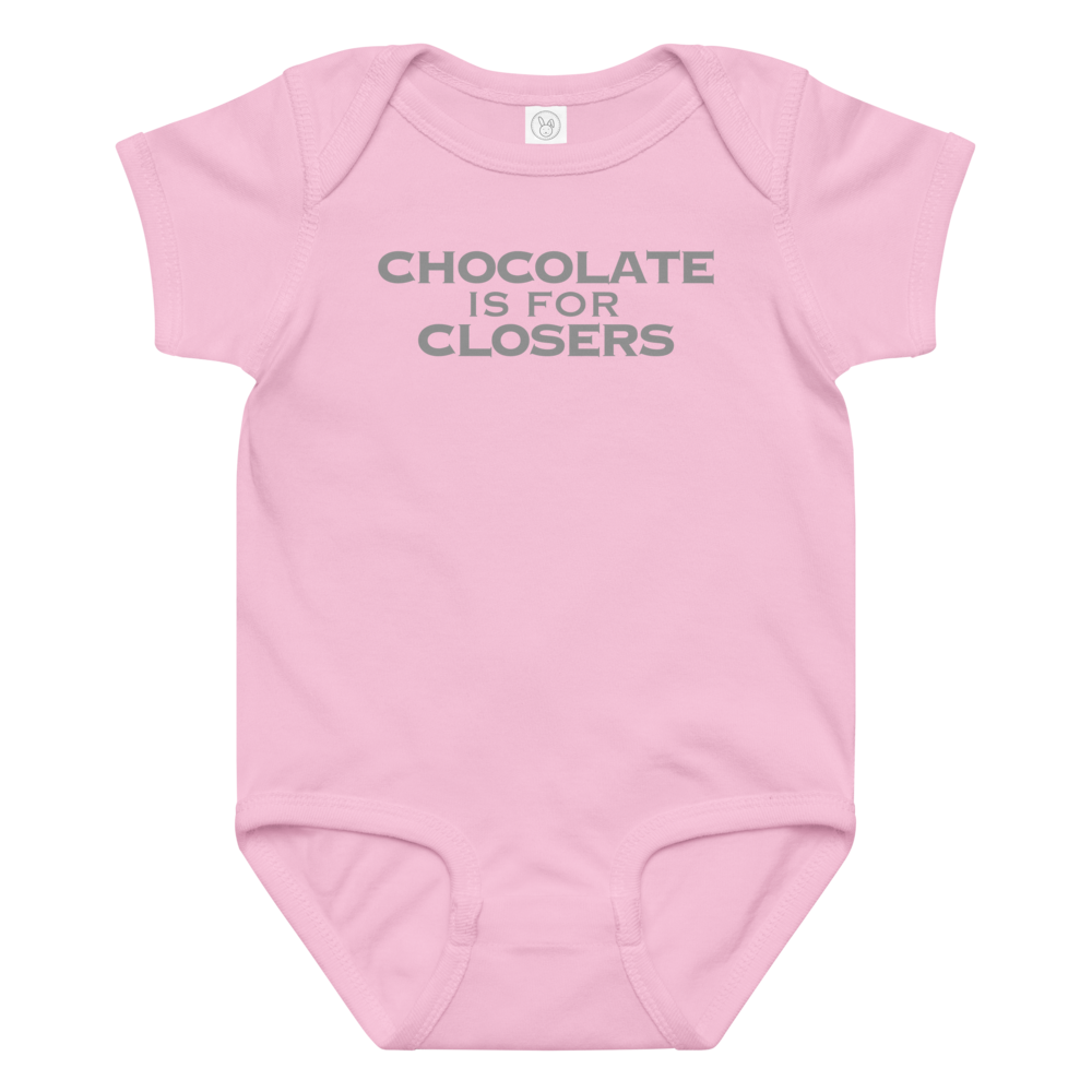 "Chocolate Is For Closers" printed on a pink baby jersey bodysuit laying on a flat surface amongst other clothes