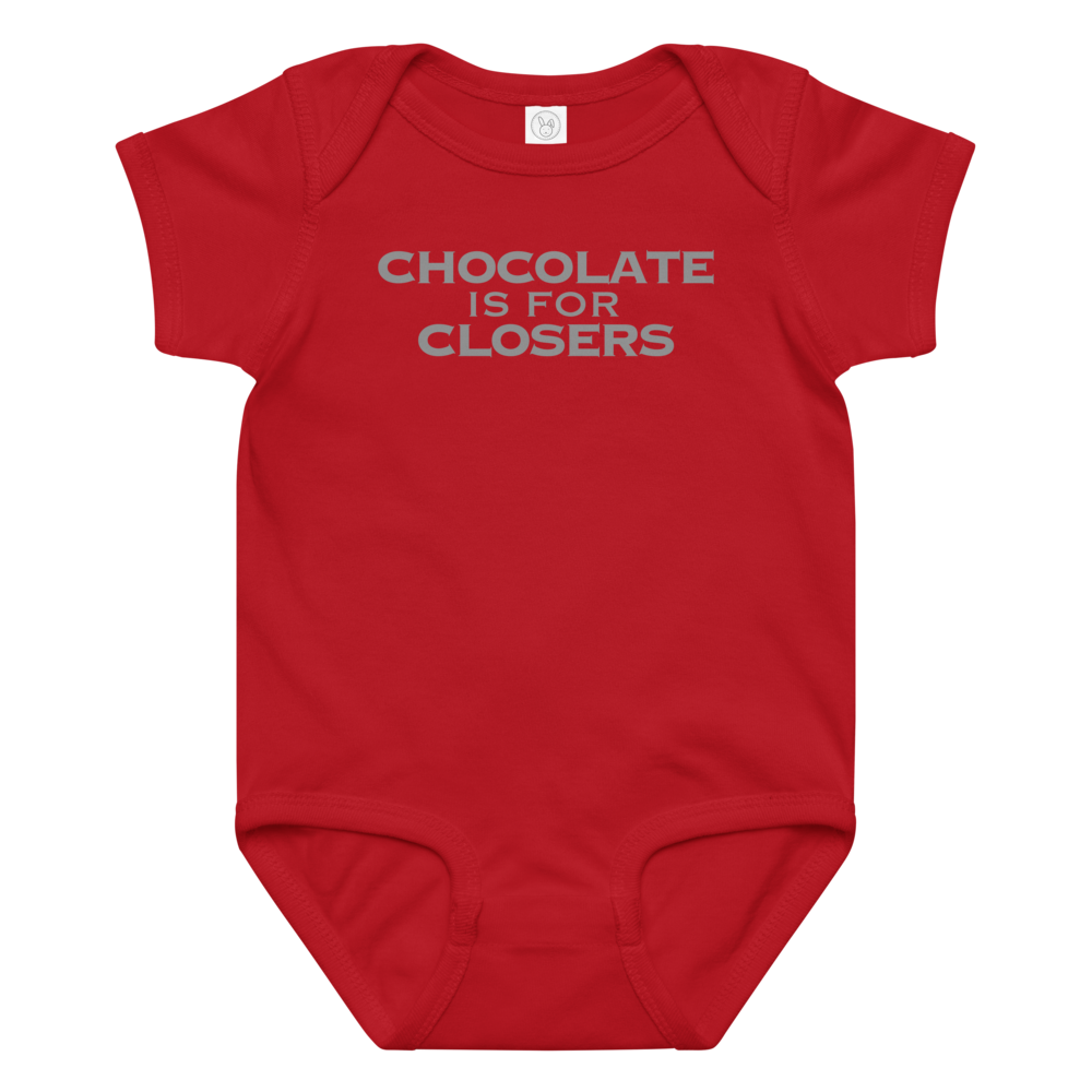 "Chocolate Is For Closers" printed on a red baby jersey bodysuit laying on a flat surface amongst other clothes