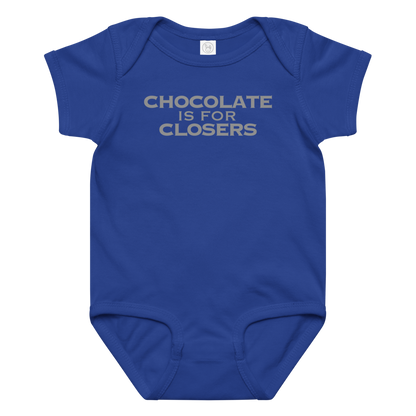 "Chocolate Is For Closers" printed on a royal baby jersey bodysuit laying on a flat surface amongst other clothes