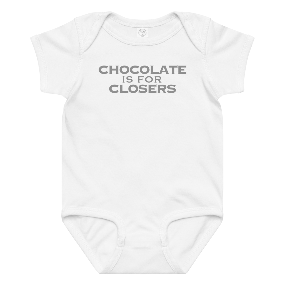 "Chocolate Is For Closers" printed on a white baby jersey bodysuit laying on a flat surface amongst other clothes