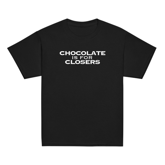 "Chocolate Is For Closers" printed on a black youth classic tee laying on a flat surface