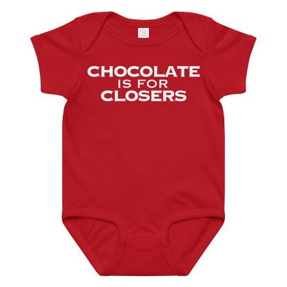 "Chocolate Is For Closers" printed on a red baby jersey bodysuit laying on a flat surface amongst other clothes