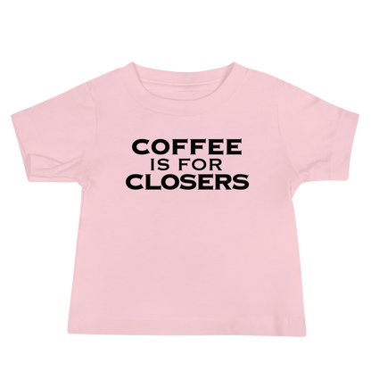 "Coffee Is For Closers" printed on a pink baby jersey short sleeve tee laying on a flat surface