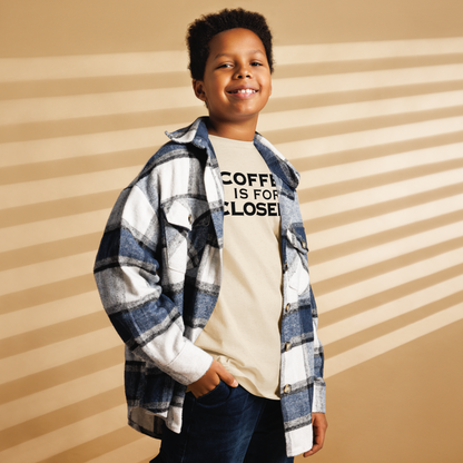 "Coffee Is For Closers" printed on a natural youth classic tee worn by a male also wearing a jacket