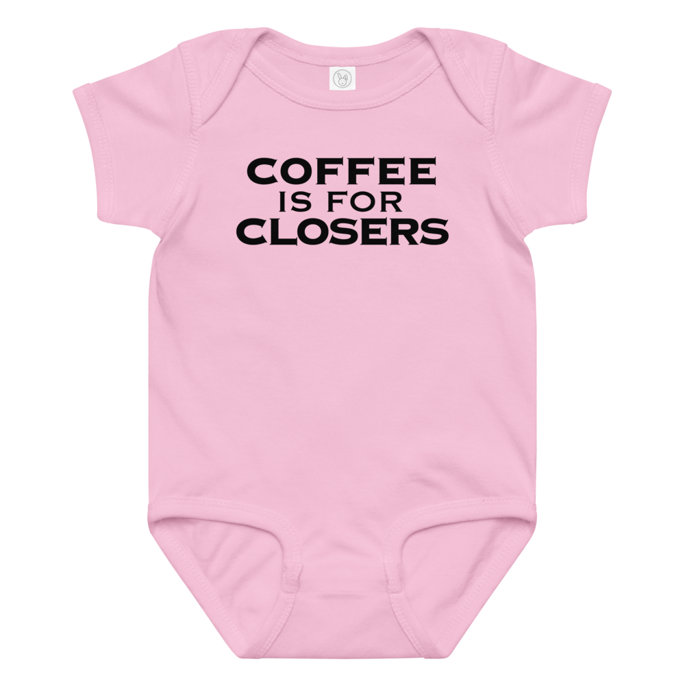 "Coffee Is For Closers" printed on a pink baby jersey bodysuit laying on a flat surface amongst other clothes