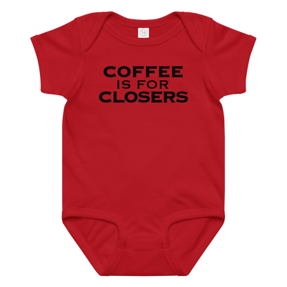"Coffee Is For Closers" printed on a red baby jersey bodysuit laying on a flat surface amongst other clothes