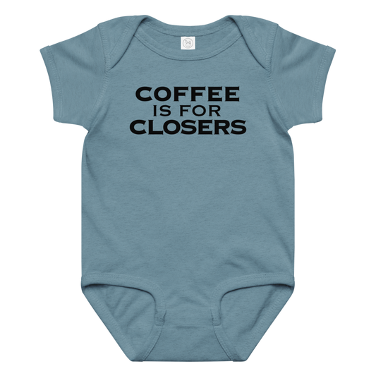 "Coffee Is For Closers" printed on a vintage indigo baby jersey bodysuit laying on a flat surface amongst other clothes