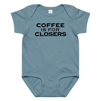 "Coffee Is For Closers" printed on a vintage indigo baby jersey bodysuit laying on a flat surface amongst other clothes