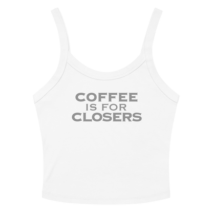 "Coffee Is For Closers" printed on a solid white blend women's micro-rib tanktop laying on a flat surface amongst sunglasses and shorts