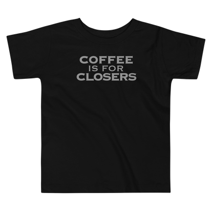 "Coffee Is For Closers" printed on a black toddler short sleeve tee laying on a flat surface