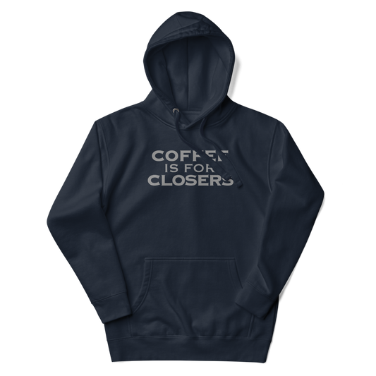"Coffee Is For Closers" printed on a navy blazer unisex hoodie laying on a flat surface with the hood up