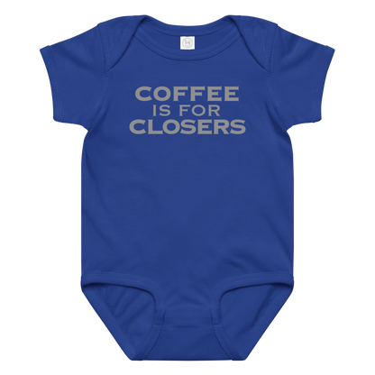 "Coffee Is For Closers" printed on a royal baby jersey bodysuit laying on a flat surface amongst other clothes