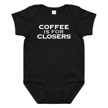 "Coffee Is For Closers" printed on a black baby jersey bodysuit laying on a flat surface amongst other clothes