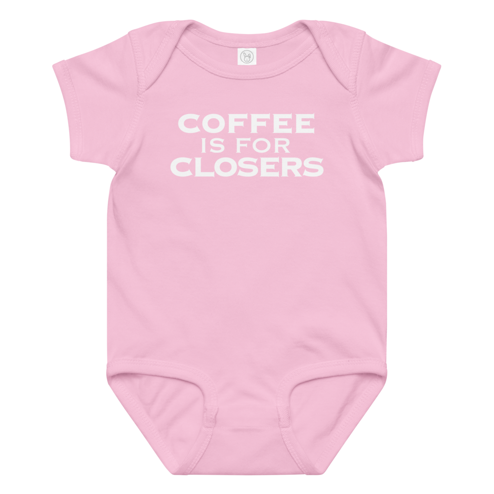 "Coffee Is For Closers" printed on a pink baby jersey bodysuit laying on a flat surface amongst other clothes