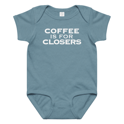 "Coffee Is For Closers" printed on a vintage indigo baby jersey bodysuit laying on a flat surface amongst other clothes