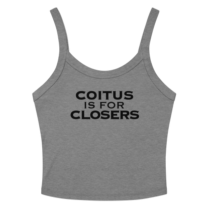 "Coitus Is For Closers" printed on a athletic heather women's micro-rib tanktop laying on a flat surface amongst sunglasses and shorts