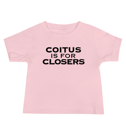 "Coitus Is For Closers" printed on a pink baby jersey short sleeve tee laying on a flat surface