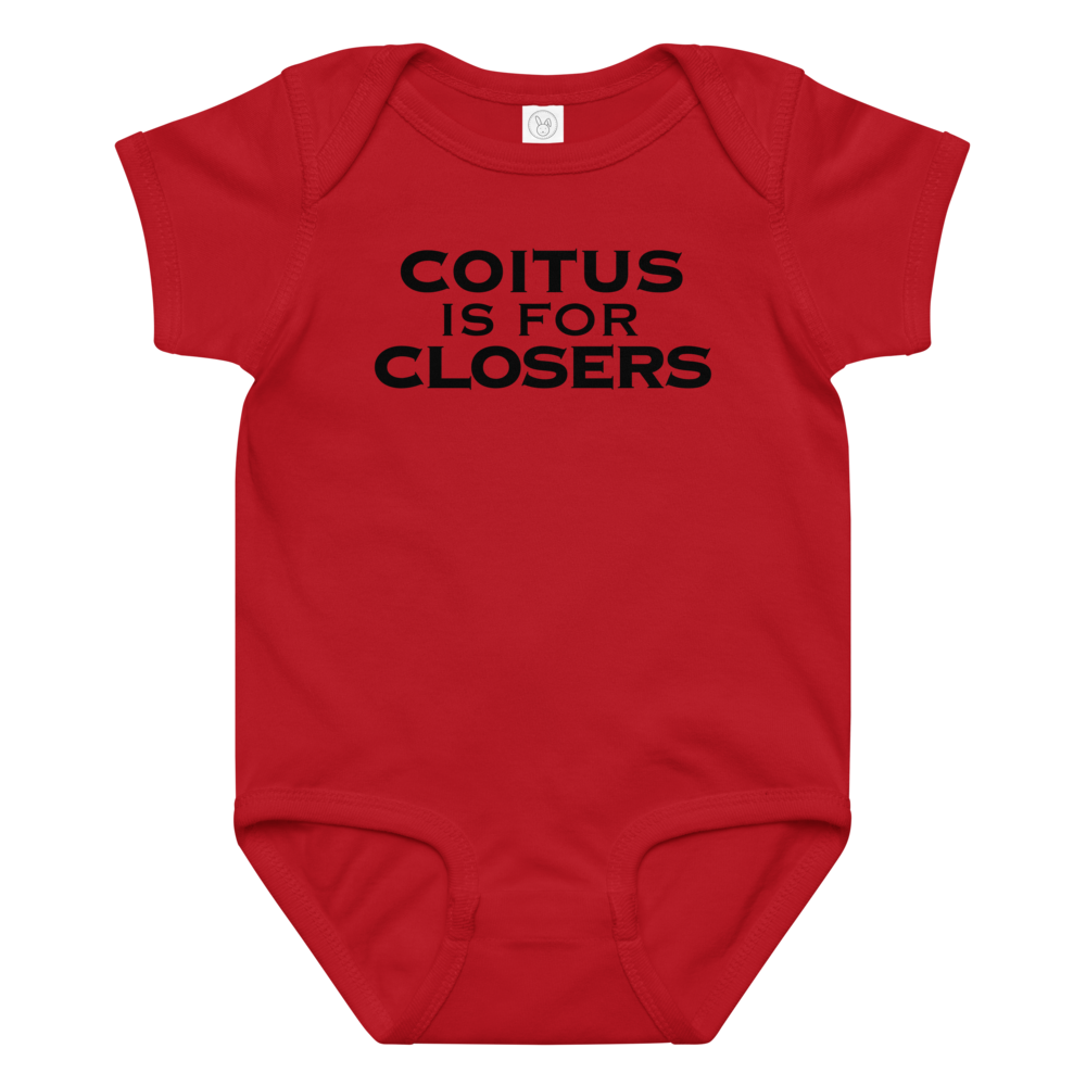 "Coitus Is For Closers" printed on a red baby jersey bodysuit laying on a flat surface amongst other clothes