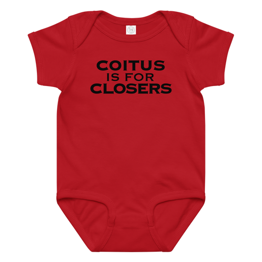 "Coitus Is For Closers" printed on a red baby jersey bodysuit laying on a flat surface amongst other clothes