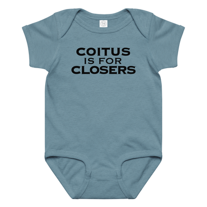 "Coitus Is For Closers" printed on a vintage indigo baby jersey bodysuit laying on a flat surface amongst other clothes