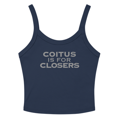 "Coitus Is For Closers" printed on a solid navy blend women's micro-rib tanktop laying on a flat surface amongst sunglasses and shorts