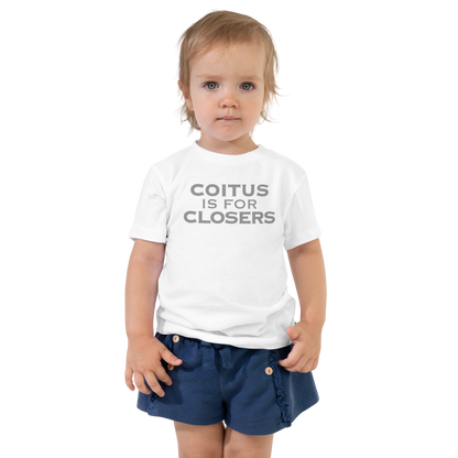 "Coitus Is For Closers" printed on a white toddler short sleeve tee worn by a female