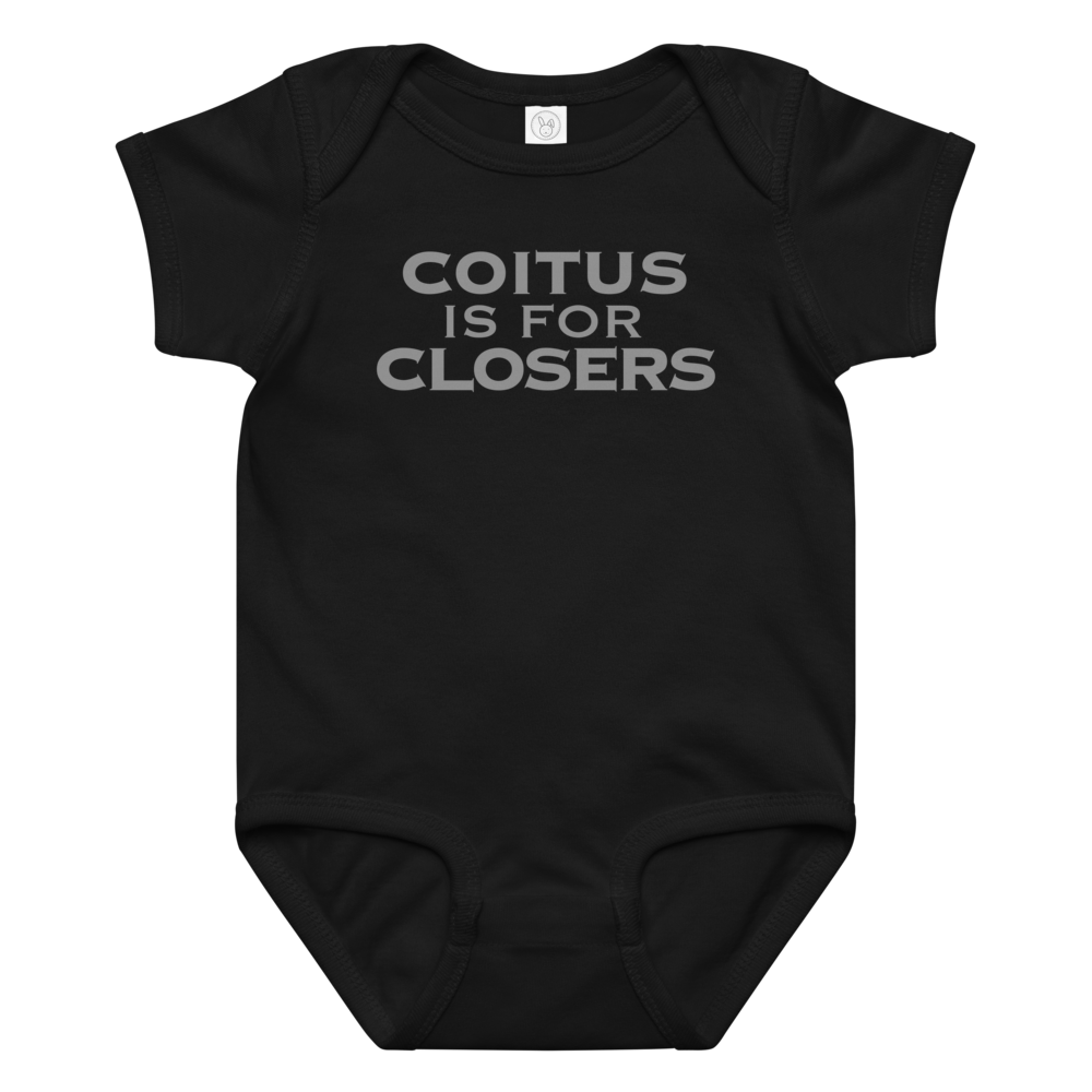 "Coitus Is For Closers" printed on a black baby jersey bodysuit laying on a flat surface amongst other clothes