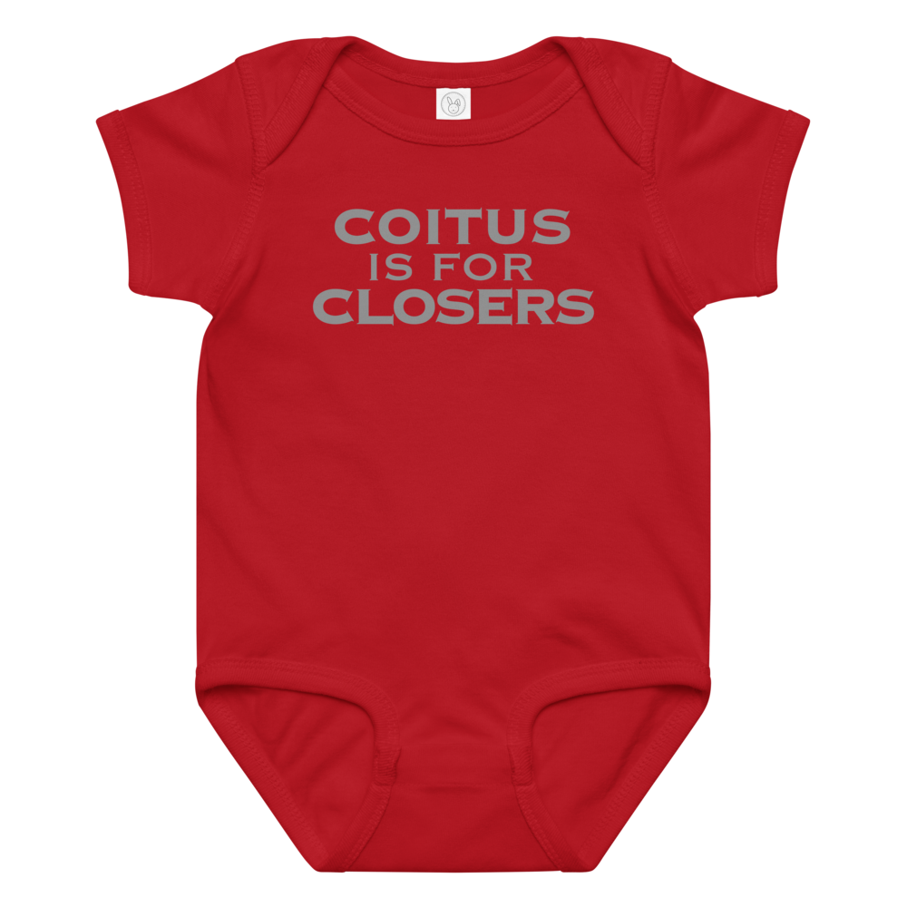 "Coitus Is For Closers" printed on a red baby jersey bodysuit laying on a flat surface amongst other clothes