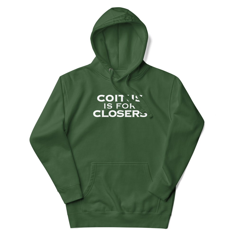 "Coitus Is For Closers" printed on a forest green unisex hoodie laying on a flat surface with the hood up