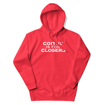 "Coitus Is For Closers" printed on a team red unisex hoodie laying on a flat surface with the hood up
