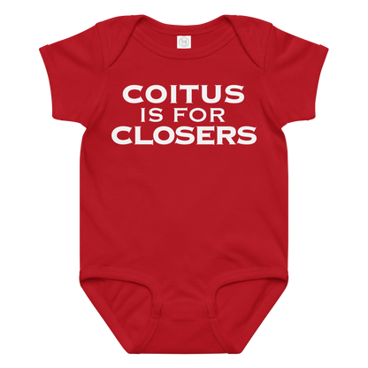 "Coitus Is For Closers" printed on a red baby jersey bodysuit laying on a flat surface amongst other clothes