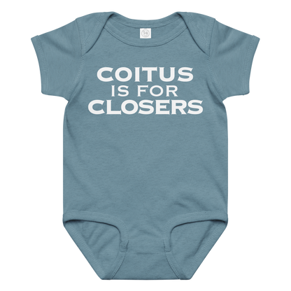 "Coitus Is For Closers" printed on a vintage indigo baby jersey bodysuit laying on a flat surface amongst other clothes