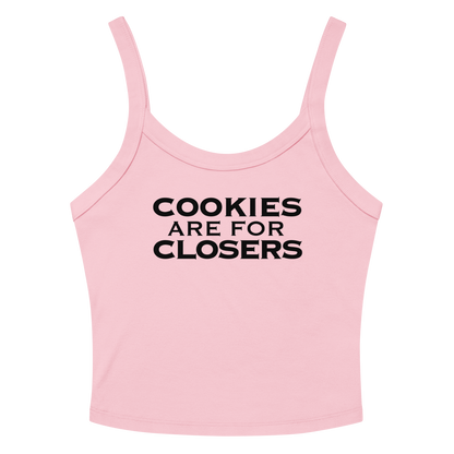 "Cookies Are For Closers" printed on a solid pink blend women's micro-rib tanktop laying on a flat surface amongst sunglasses and shorts