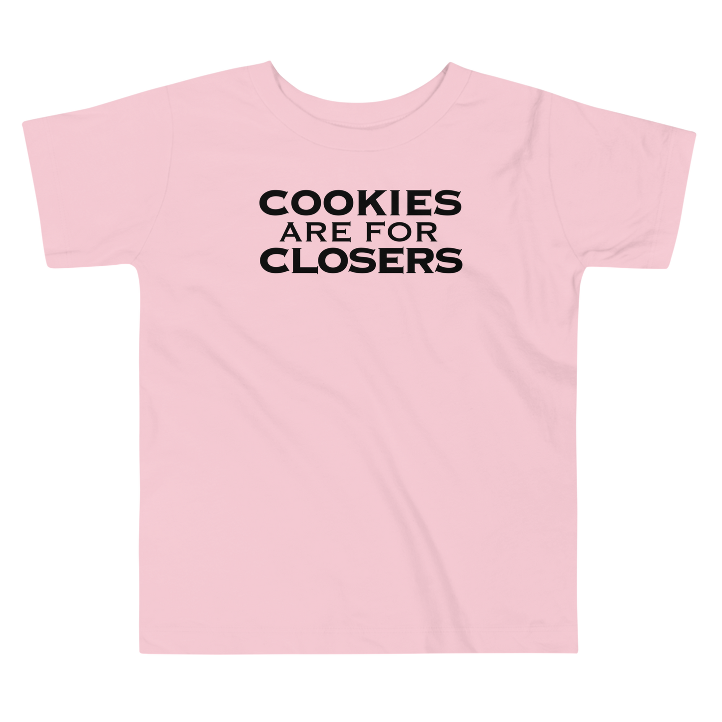 "Cookies Are For Closers" printed on a pink toddler short sleeve tee laying on a flat surface
