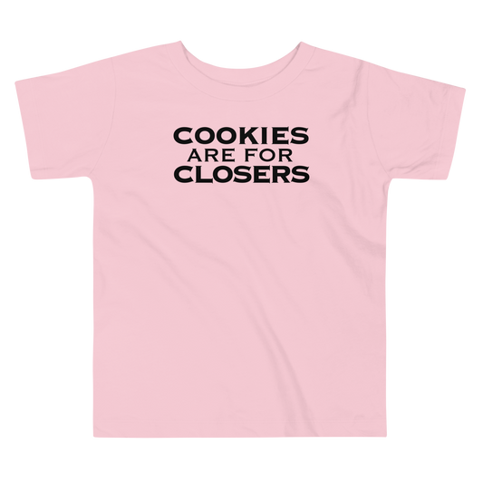 "Cookies Are For Closers" printed on a pink toddler short sleeve tee laying on a flat surface