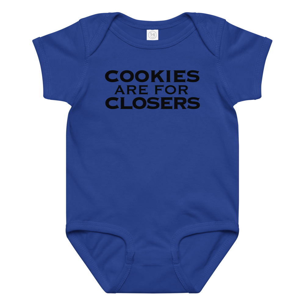 "Cookies Are For Closers" printed on a royal baby jersey bodysuit laying on a flat surface amongst other clothes