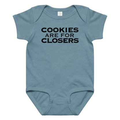 "Cookies Are For Closers" printed on a vintage indigo baby jersey bodysuit laying on a flat surface amongst other clothes