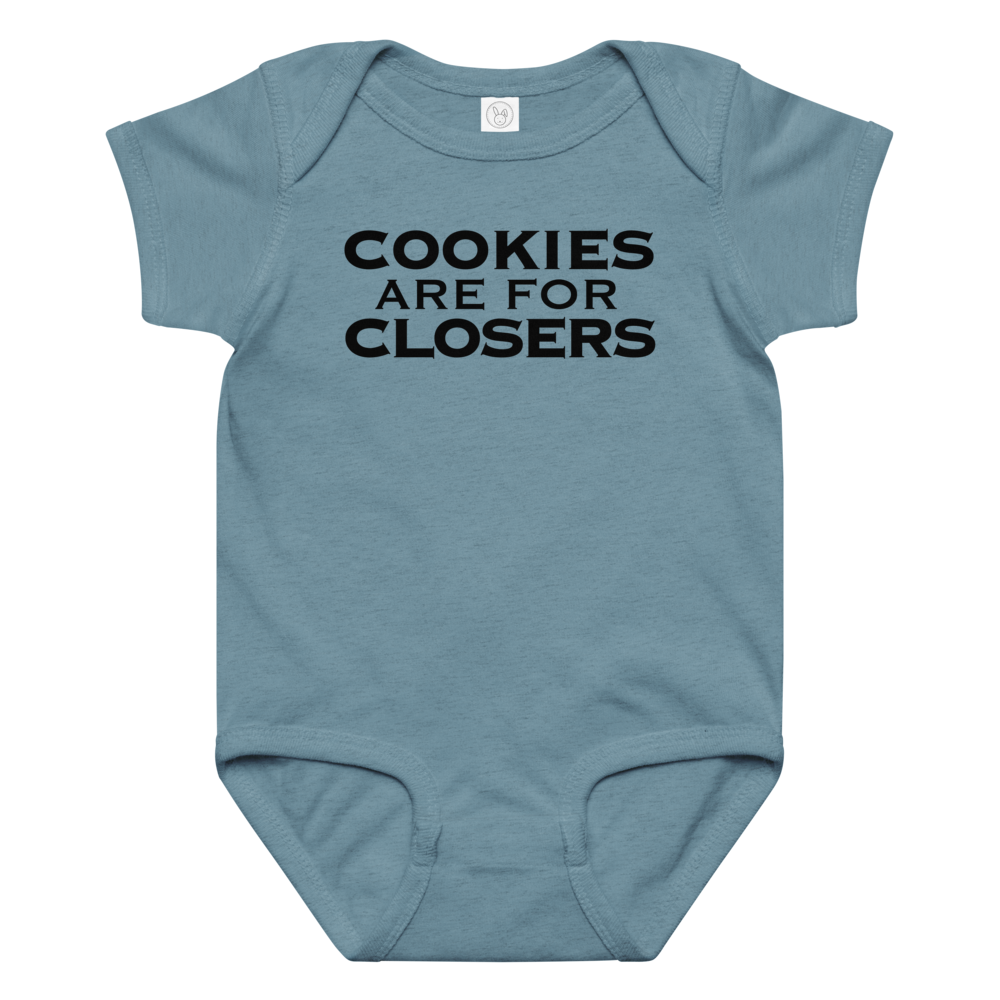 "Cookies Are For Closers" printed on a vintage indigo baby jersey bodysuit laying on a flat surface amongst other clothes