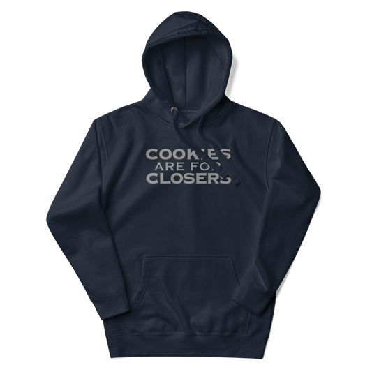 "Cookies Are For Closers" printed on a navy blazer unisex hoodie laying on a flat surface with the hood up
