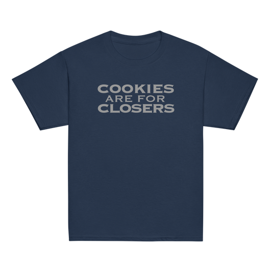 "Cookies Are For Closers" printed on a navy youth classic tee laying on a flat surface
