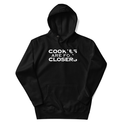 "Cookies Are For Closers" printed on a black unisex hoodie laying on a flat surface with the hood up