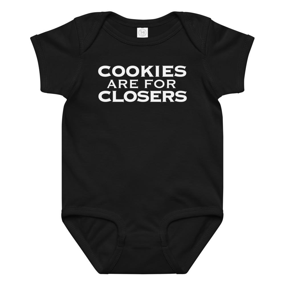 "Cookies Are For Closers" printed on a black baby jersey bodysuit laying on a flat surface amongst other clothes