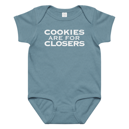 "Cookies Are For Closers" printed on a vintage indigo baby jersey bodysuit laying on a flat surface amongst other clothes