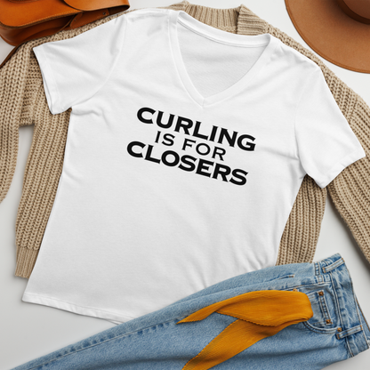 "Curling Is For Closers" printed on a solid white blend women's relaxed v-neck t-shirt laying on a flat surface amongst other clothes
