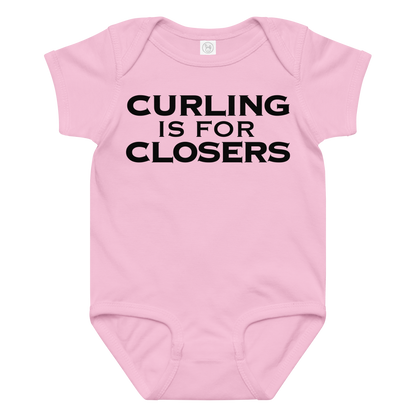 "Curling Is For Closers" printed on a pink baby jersey bodysuit laying on a flat surface amongst other clothes