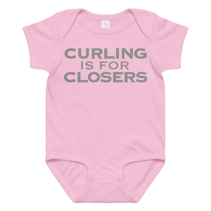 "Curling Is For Closers" printed on a pink baby jersey bodysuit laying on a flat surface amongst other clothes