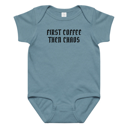"First Coffee  Then Chaos" printed on a vintage indigo baby jersey bodysuit laying on a flat surface amongst other clothes