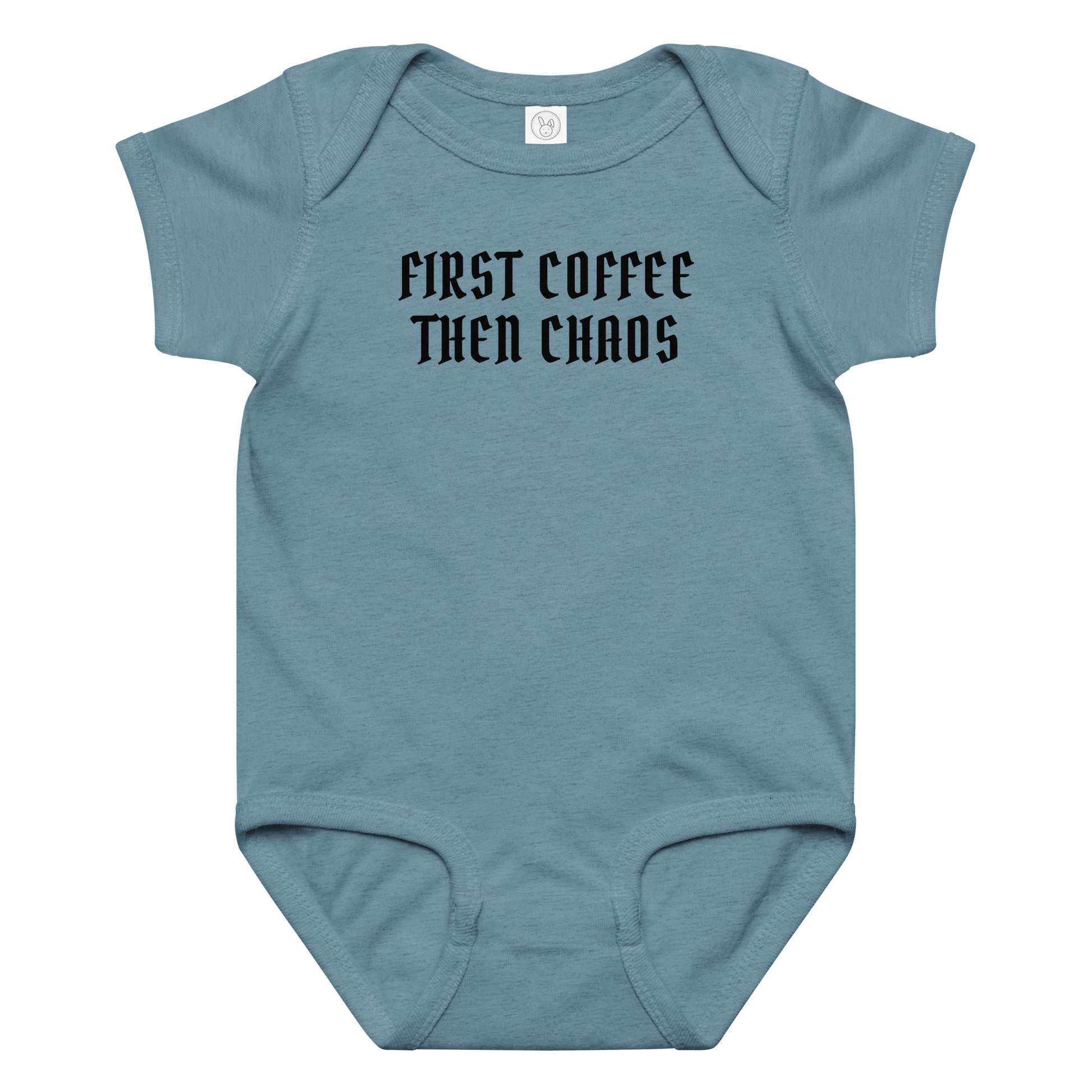"First Coffee  Then Chaos" printed on a vintage indigo baby jersey bodysuit laying on a flat surface amongst other clothes